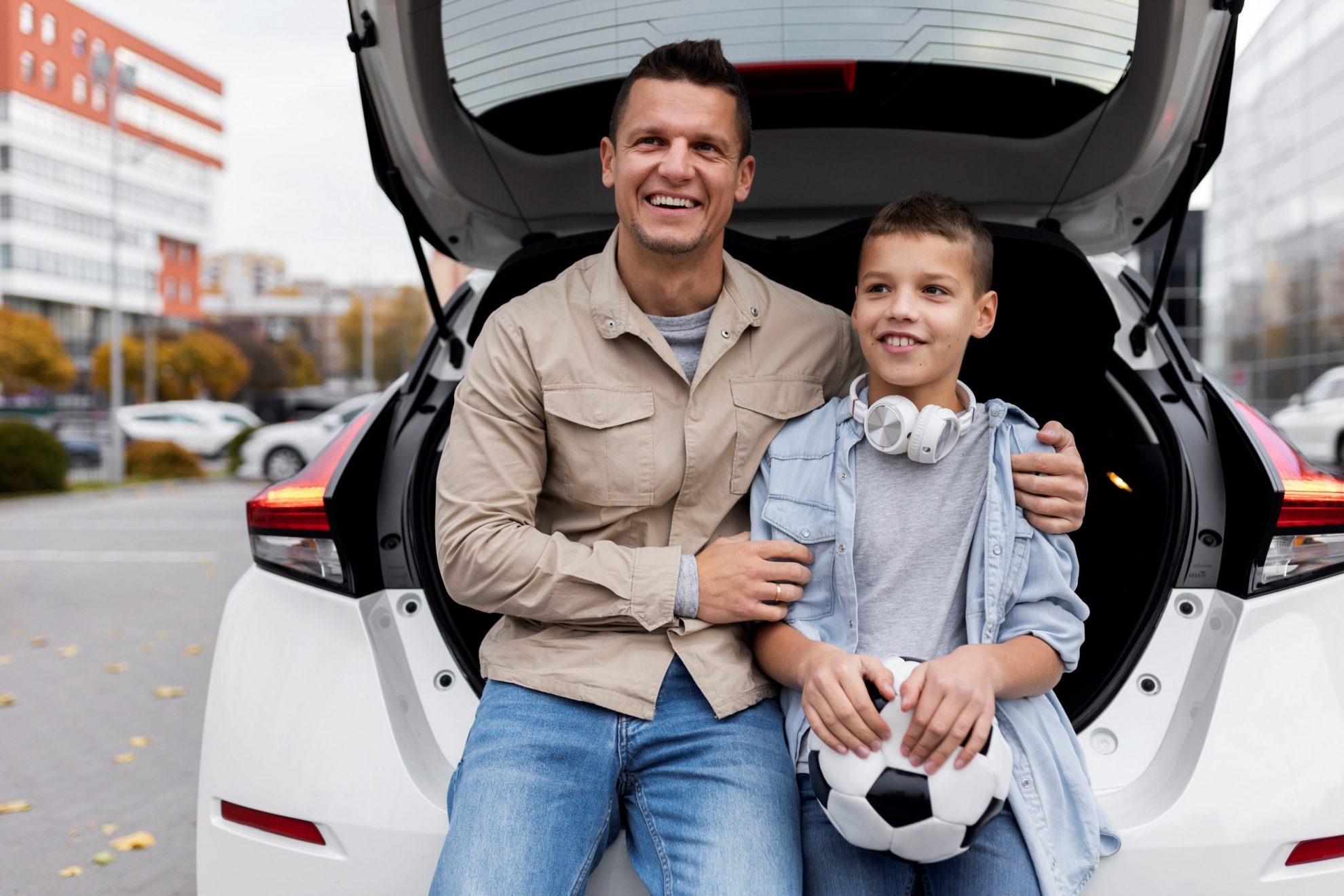 Photo of man with son in front of car illustrates blog: "Auto Insurance: What You Need to Know"