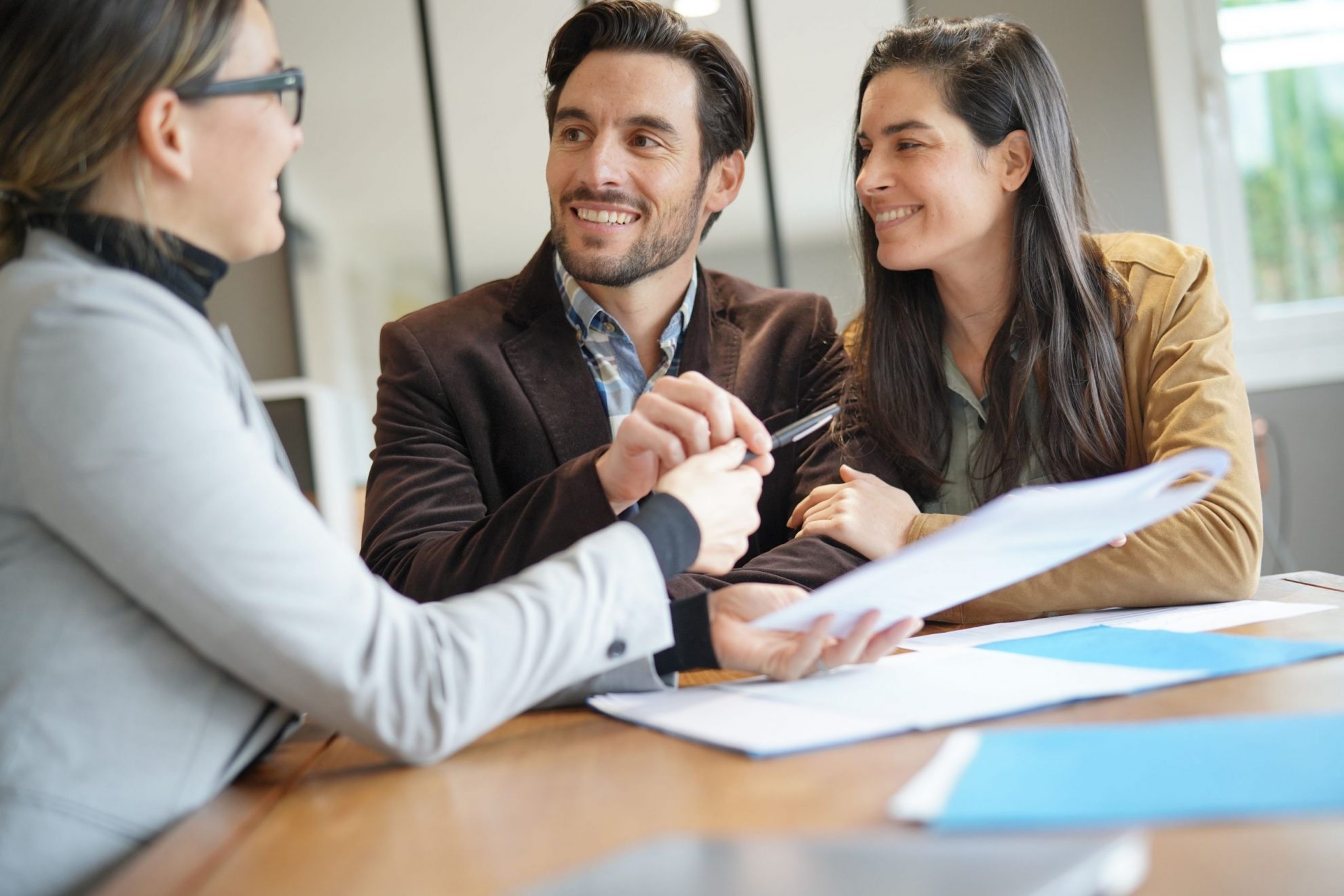 Photo of man and woman lookinPhoto of man and woman talking with female insurance agent illustrates blog: "Making Sense of Insurance: 10 Terms You Need to Know"
