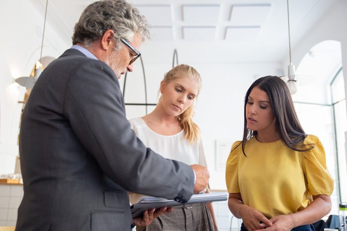 Photo of man talking with two women illustrates blog: "Who Needs Professional Liability Insurance?"