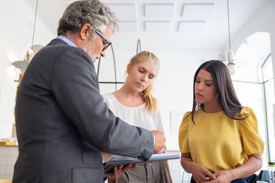 Photo of man talking with two women illustrates blog: "Who Needs Professional Liability Insurance?"