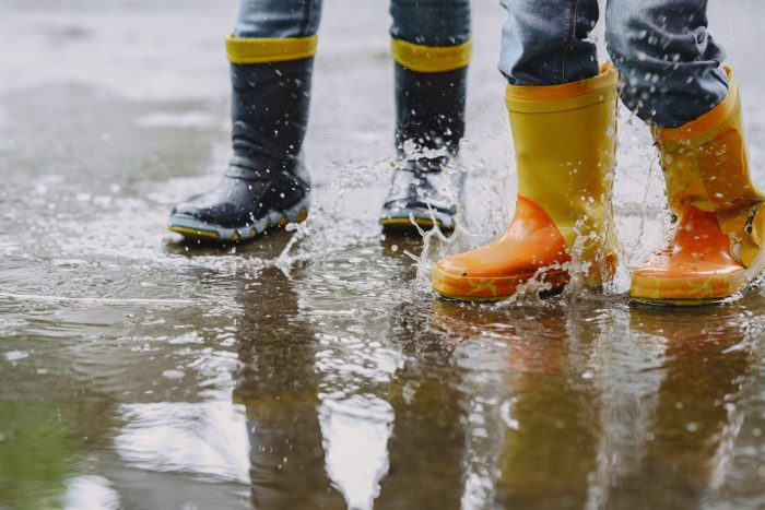 Photo of kids wearing rain boots in puddle illustrates blog:; "Rainy Season Is Here: This Is the Right Time to Get Flood Insurance"