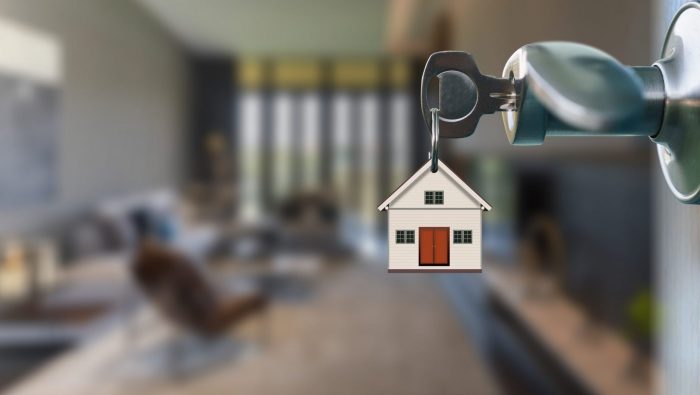 Photo if key in doorknob with keychain in the shape of a house illustrates blog: "Houston Homeowners Insurance: What Is the Difference Between HO2 and HO3 Policies?"