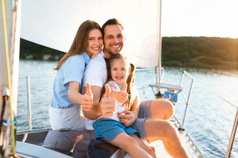 Photo of family giving the thumbs up on boat illustrates blog: "What Are the Types of Boat Insurance Available in Texas?"
