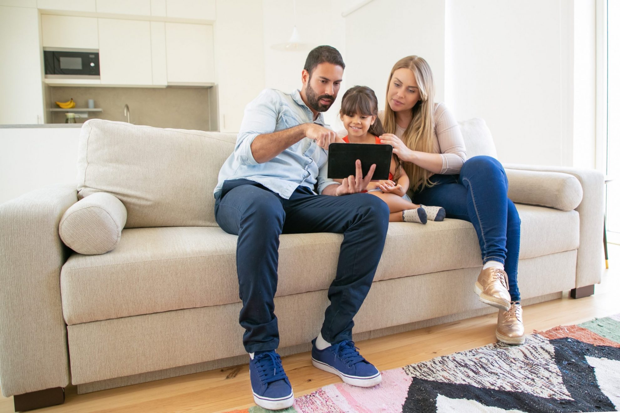 Photo of family in living room with tablet illustrates blog "What Personal Belongings Are Covered by Home Insurance?v"