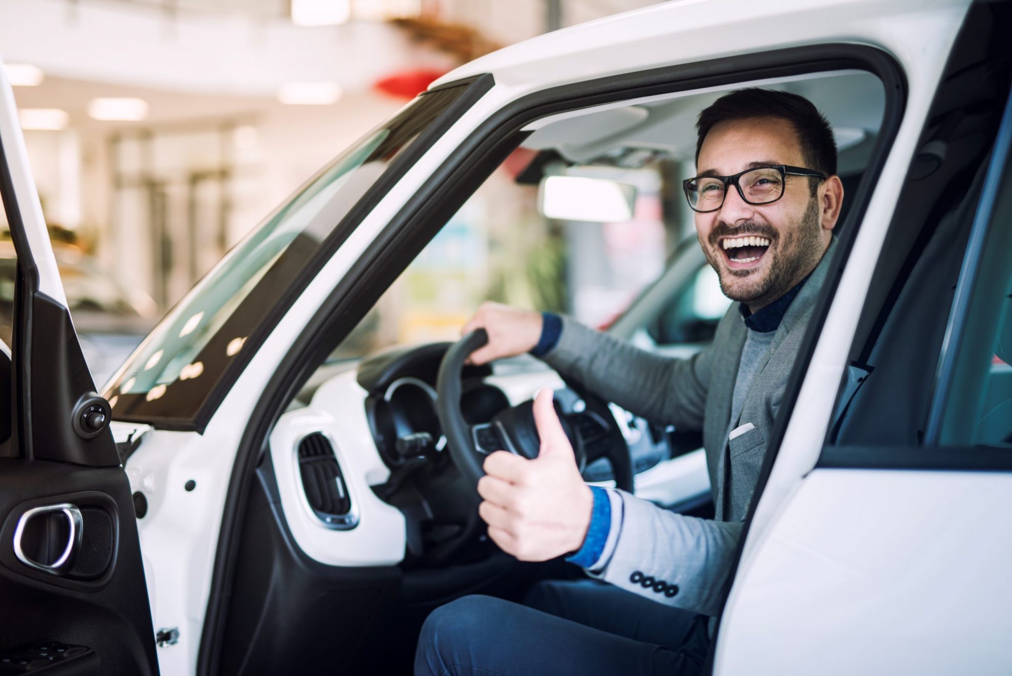 Photo of man giving the thumbs up in a car illustrates blog: "What Is a Declarations Page in Auto Insurance?"